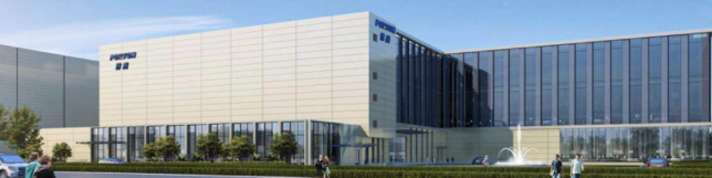 The large modern building at the Porton site boasts glass windows and a fountain in front, set amid lush greenery, showcasing its state-of-the-art construction as a premier drug product GMP facility.
