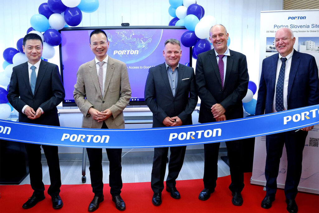 Five men in business attire stand behind a ribbon labeled "PORTON" at an Investment Forum event. Slovenian officials mingle among blue and white balloons in the background.